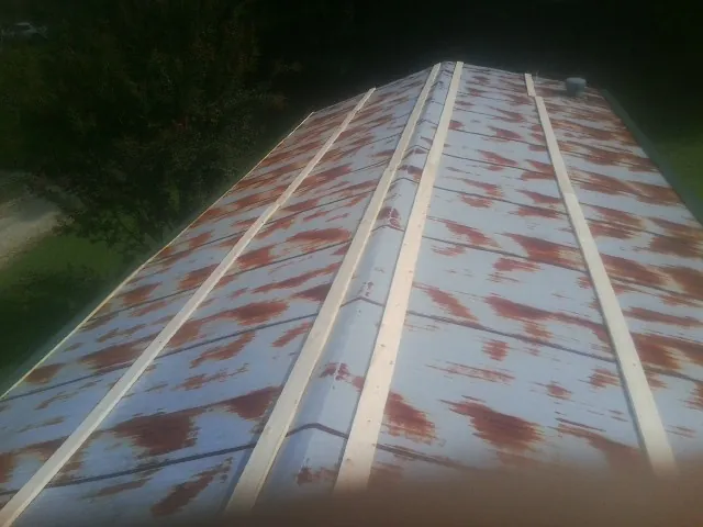 Rusted metal roof panels with new wood purlins before replacement — Storm Damage Roof Repair in Kennebunkport by Roofing Brothers