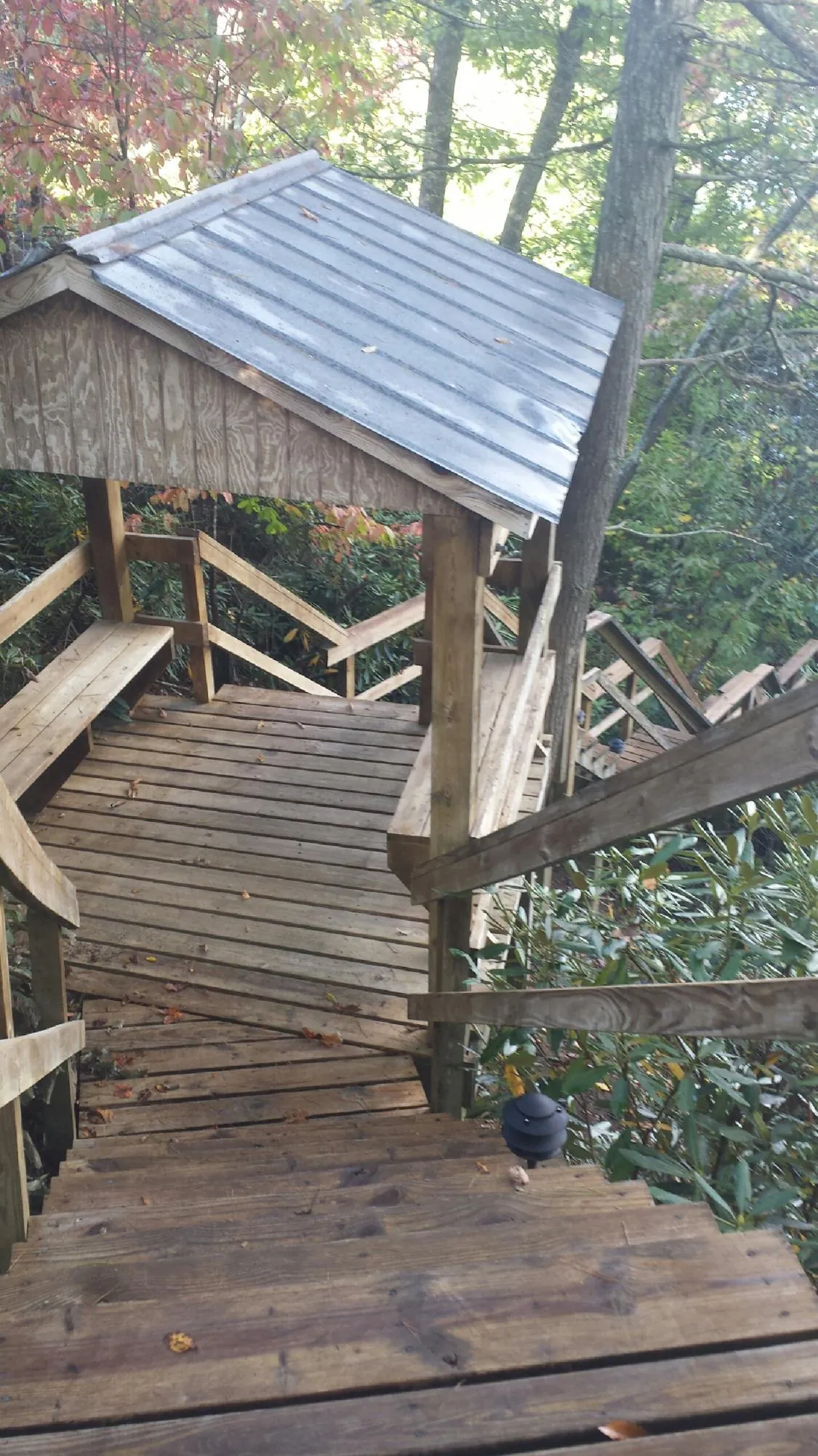 Metal roofed shelter over wooden steps on a wooded walkway — Skylight Repair & Installation work by our crew in Kennebunkport