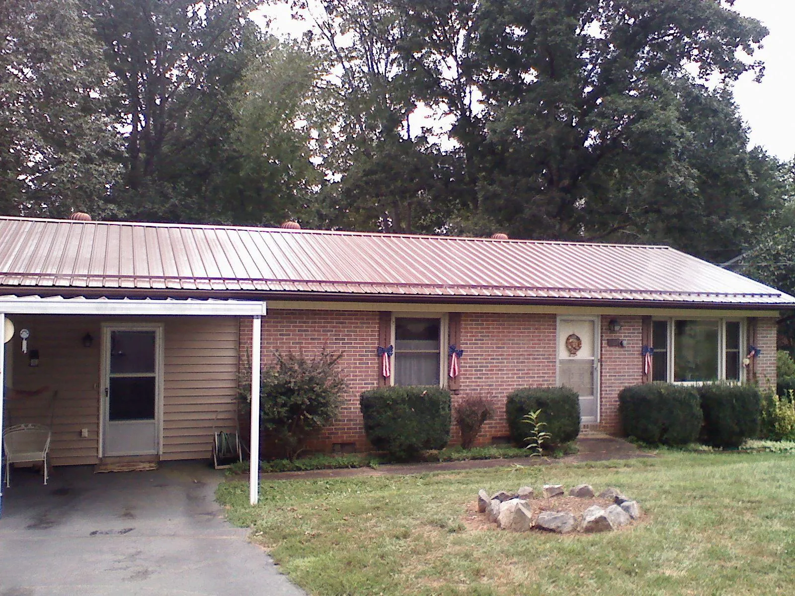 Bronze metal roof and carport on a brick ranch home — Roof Repair work by our crew in Kennebunkport